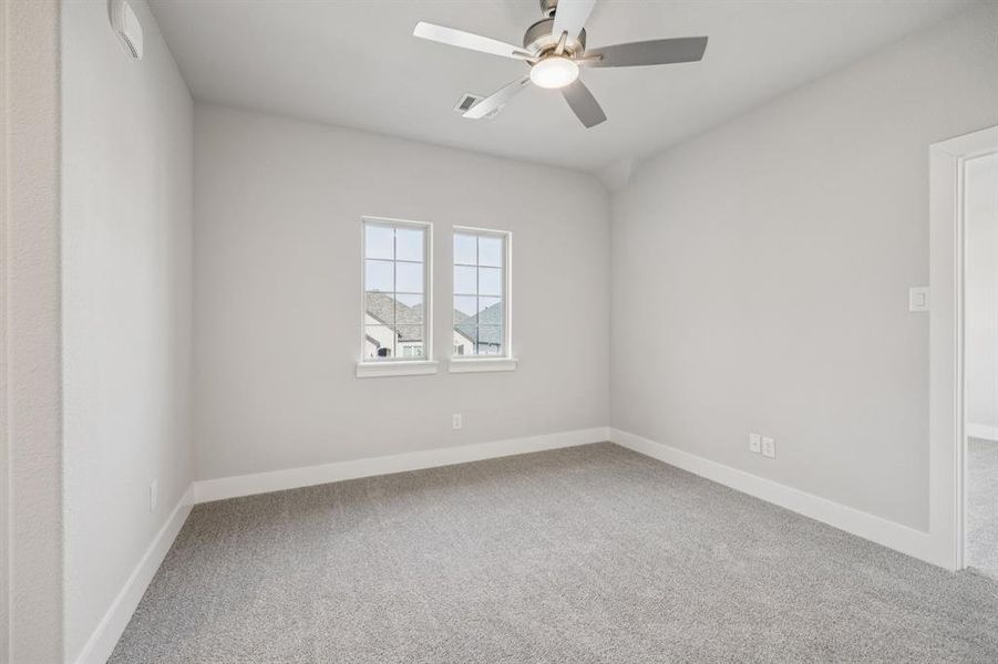 Empty room featuring light carpet and ceiling fan Empty room featuring light carpet and ceiling fan