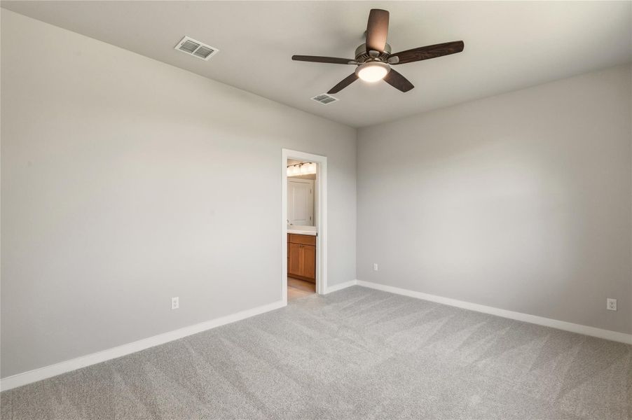 Unfurnished room featuring light colored carpet and a ceiling fan