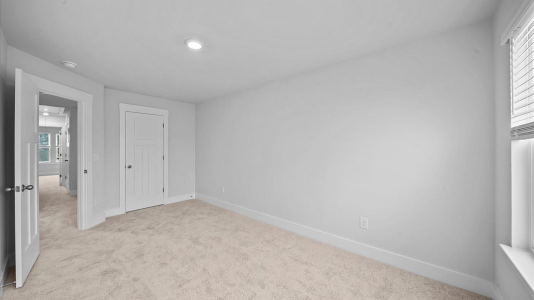 Bedroom with plush carpet underfoot and a thoughtfully planned walk-in closet at Saluda Crossing by DRB Homes in Piedmont, SC