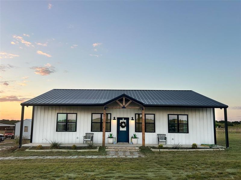 Modern farmhouse featuring a porch, board and batten siding, and a front lawn Modern farmhouse featuring a porch, board and batten siding, and a front lawn