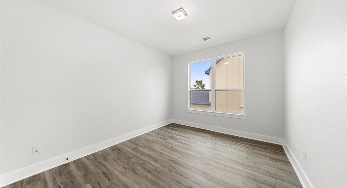 Spare room featuring wood finished floors and baseboards