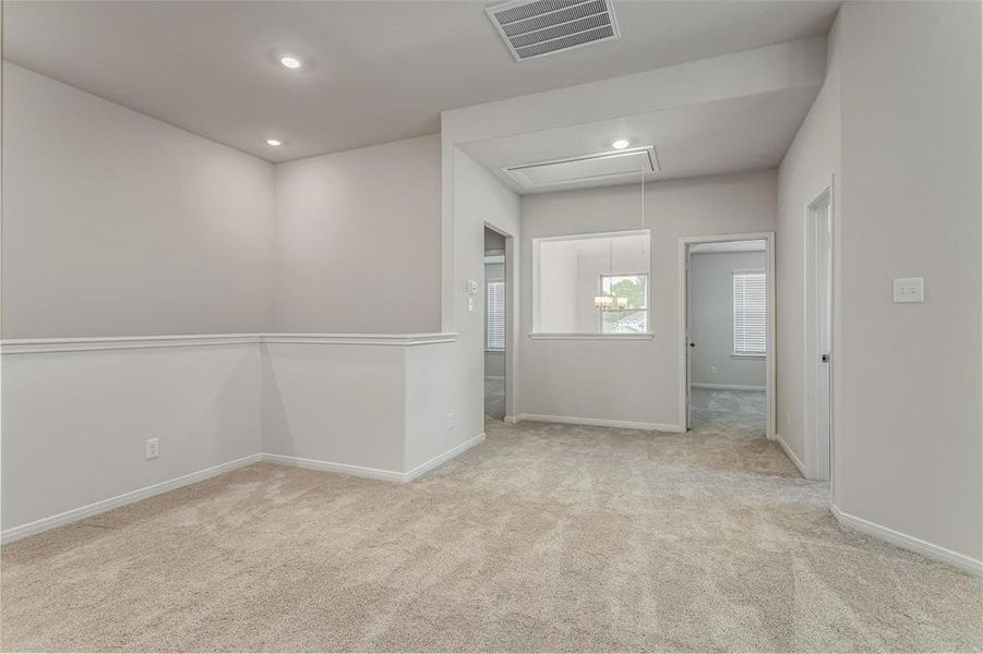 This versatile hallway area can serve as a welcoming foyer or a functional transitional space between rooms. Recessed lighting and soft carpeting add warmth and comfort, while the open layout offers a glimpse into the adjacent rooms, creating a seamless flow throughout the home. Photos are from another Rylan floor plan.