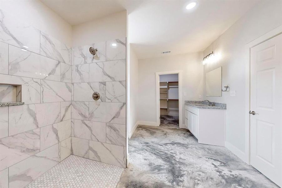 Bathroom with vanity and tiled shower