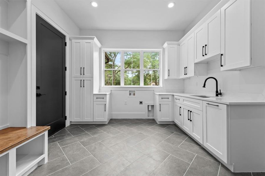 Laundry room off the garage with full size sink, cabinets/drawers and back pack drop zone.