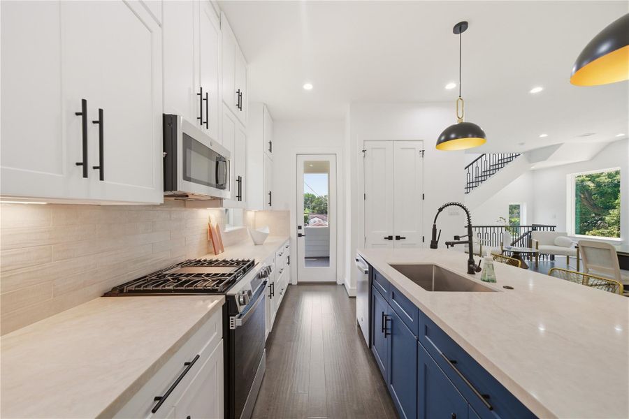 Taj Mahal Quartz countertops on beautiful waterfall design. With contrasting blue island cabinets and stainless steel appliances. Soft closing cabinets all around, with plenty of storage.
