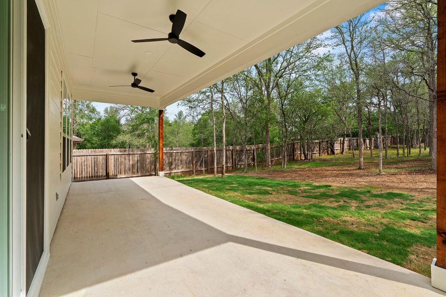 Fenced backyard featuring a patio and a ceiling fan