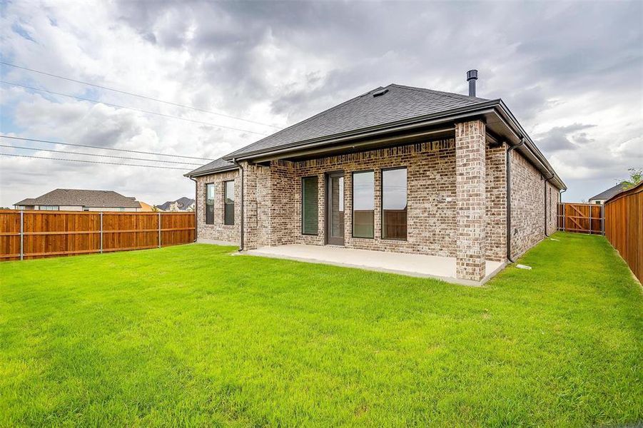 Back of property featuring a yard and a patio