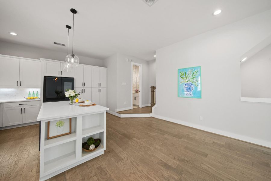 With pantry-depth cabinets above and to the right of the refrigerator, a lack of storage will not be an issue in this home! The kitchen flows onto the landing leading to a convenient half bath and the stairwell to the third floor. With pantry-depth cabinets above and to the right of the refrigerator, a lack of storage will not be an issue in this home! The kitchen flows onto the landing leading to a convenient half bath and the stairwell to the third floor.