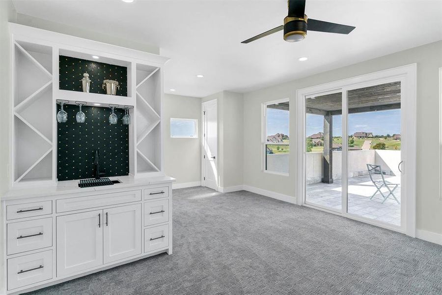 Unfurnished living room featuring carpet and ceiling fan