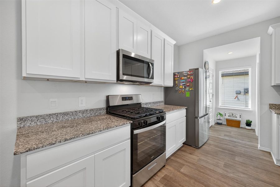 A chef’s kitchen boasting granite surfaces, custom cabinetry, and premium stainless steel appliances.