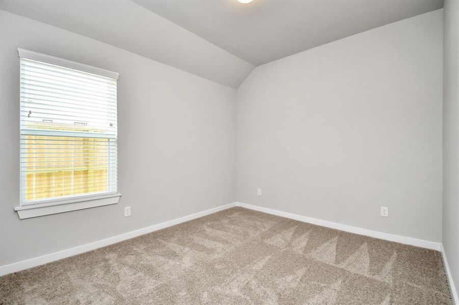 A cozy secondary bedroom with large windows, plush carpet, and spacious closets. The natural light and neutral colors create a serene, inviting atmosphere. Sample photo of similar plan. Actual colors and selections may vary.