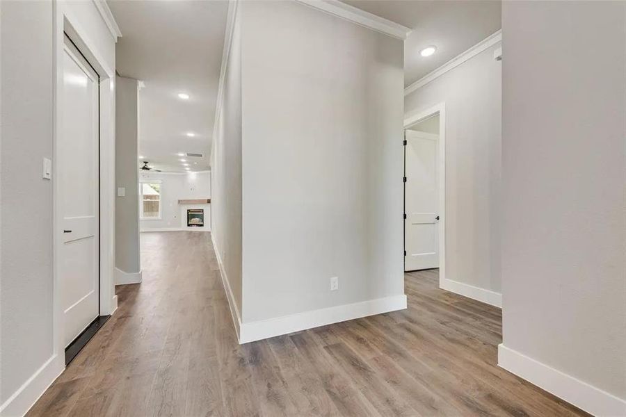 Hallway featuring light wood finished floors, recessed lighting, and crown molding