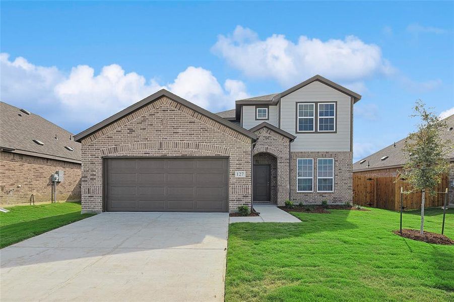 Front facade featuring a front yard and a garage