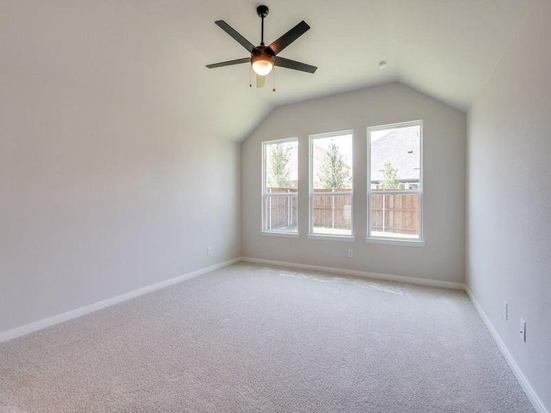 A wall of windows provides a peaceful and relaxing back yard view in this owner's suite.