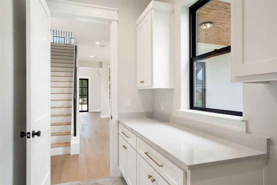 A well-appointed service area with elegant white cabinetry and a spacious counter. A well-appointed service area with elegant white cabinetry and a spacious counter.