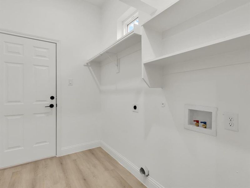 Clothes washing area featuring washer hookup, electric dryer hookup, hookup for a gas dryer, and light hardwood / wood-style flooring