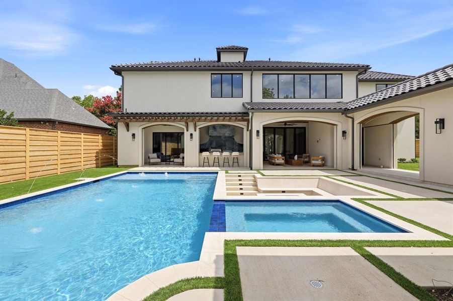 Step outside to discover a true retreat, featuring a sunken firepit, a sparkling pool and spa, an outdoor kitchen, and motorized shades for the patio and breezeway. The turf lawn provides ample space for play, while a dog wash station or outdoor shower adds a touch of practicality to this luxurious setting.