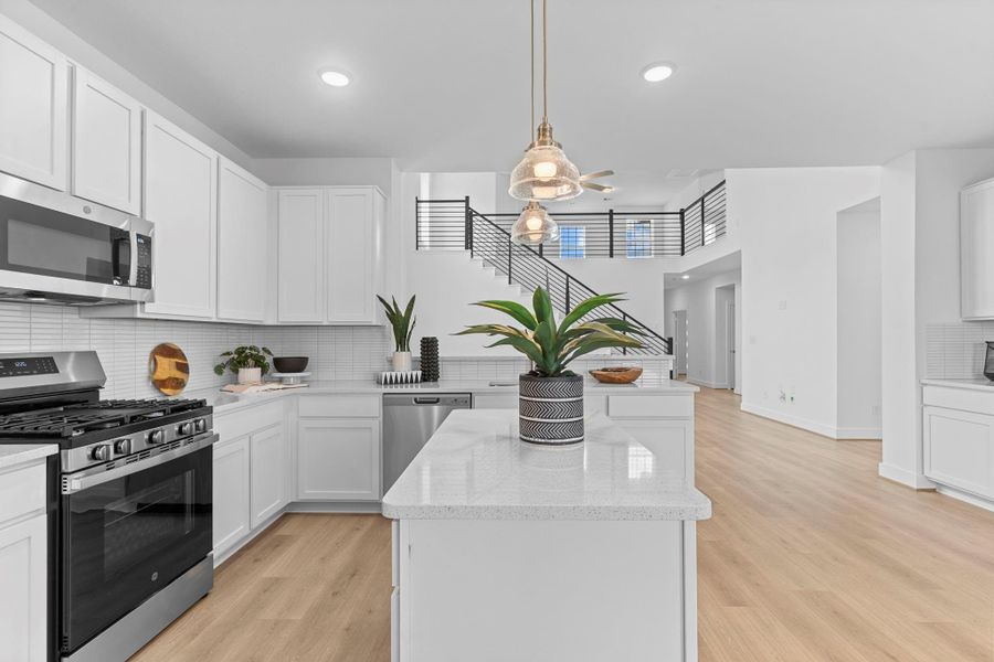 This kitchen’s central island serves as both a prep space and stylish focal point, accented by pendant lighting, granite countertops, and surrounding cabinetry that blends form and function. **Image Representative of Plan Only and May Vary as Built**.