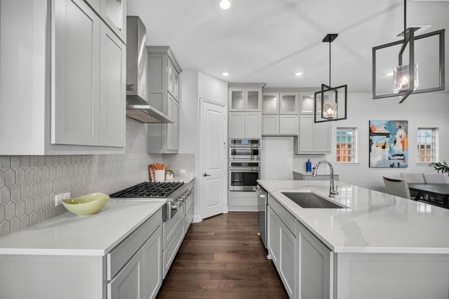 Contemporary kitchen featuring light gray cabinetry, white countertops, and wood-finish flooring