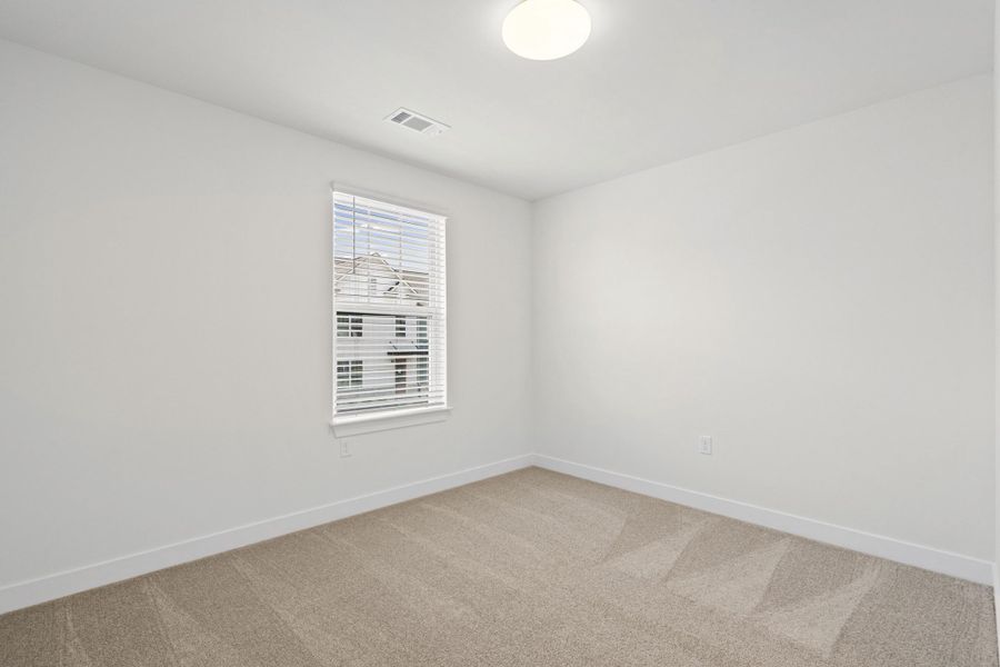 Room with neutral carpet flooring, white walls, and a single window with blinds