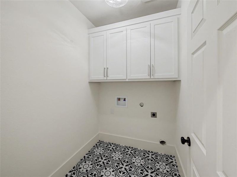 Laundry area with hookup for a gas dryer, hookup for a washing machine, cabinet space, hookup for an electric dryer, and light tile patterned flooring