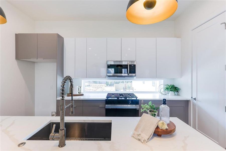 Kitchen featuring sink, stainless steel appliances, and white cabinets