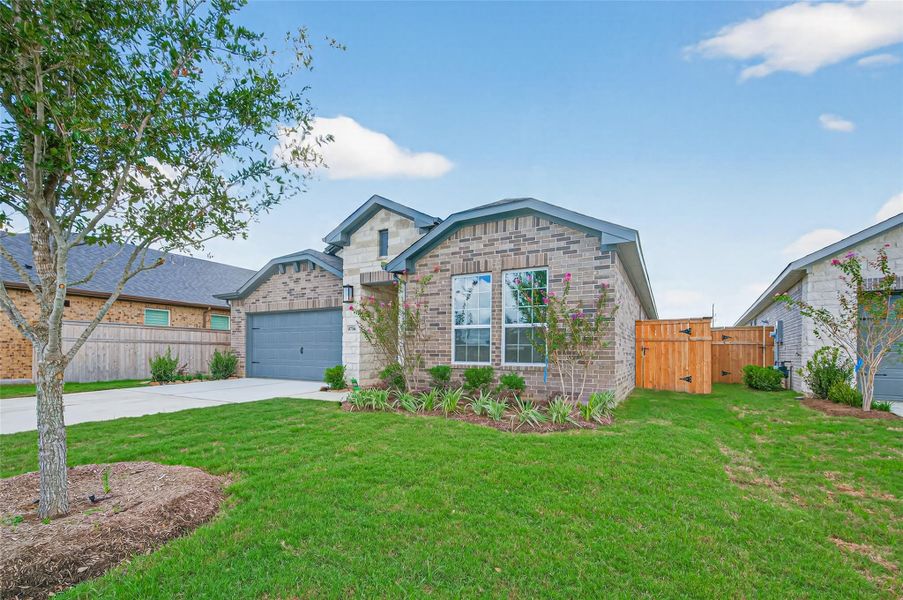 Beautiful front windows bring in natural light and are framed by fresh landscaping that enhances the home’s charming curb appeal.
