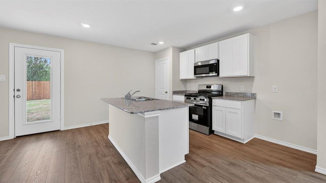 Kitchen featuring wood-finish flooring, recessed lighting, and white cabinetry