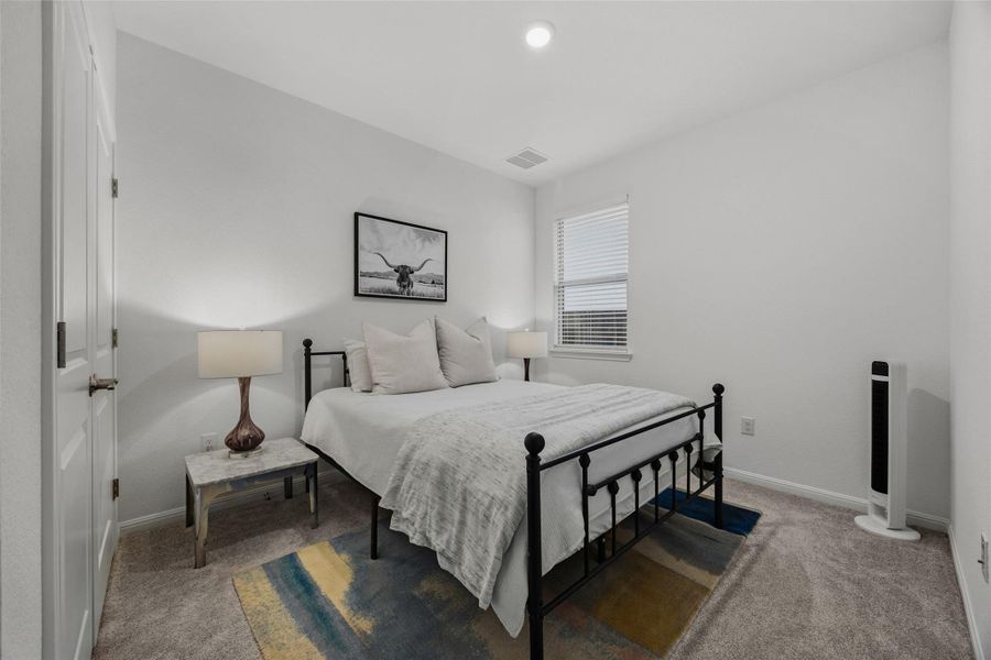 Bedroom featuring light-toned carpeting, white walls, and a window with horizontal blinds