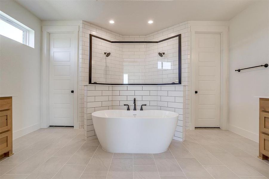 Bathroom featuring vanity, independent shower and bath, tile patterned floors, and tile walls