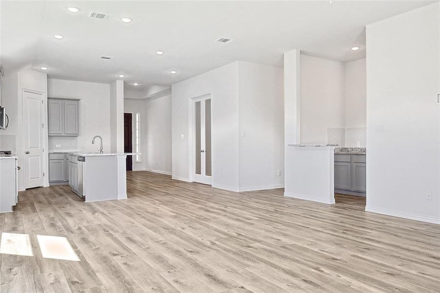 Unfurnished living room with light wood-type flooring and sink