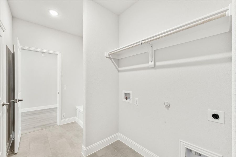Laundry room with wall-mounted drying rod, washer and dryer hookups, and tile flooring Laundry room with wall-mounted drying rod, washer and dryer hookups, and tile flooring