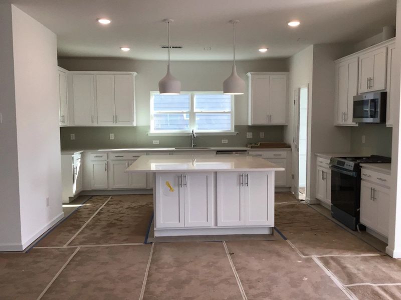 Kitchen featuring the AW Collection® Coastal - White cabinets and sea-glass tile backsplash.