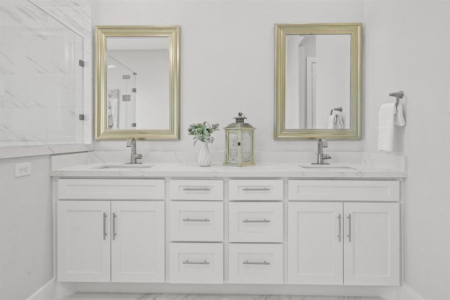 The extended vanity comes equipped with two undermount sinks, brushed nickel finishes, soft-close drawers, and custom framed mirrors. A storage closet, not pictured, provides additional storage for extra towels, linens, and toiletries.