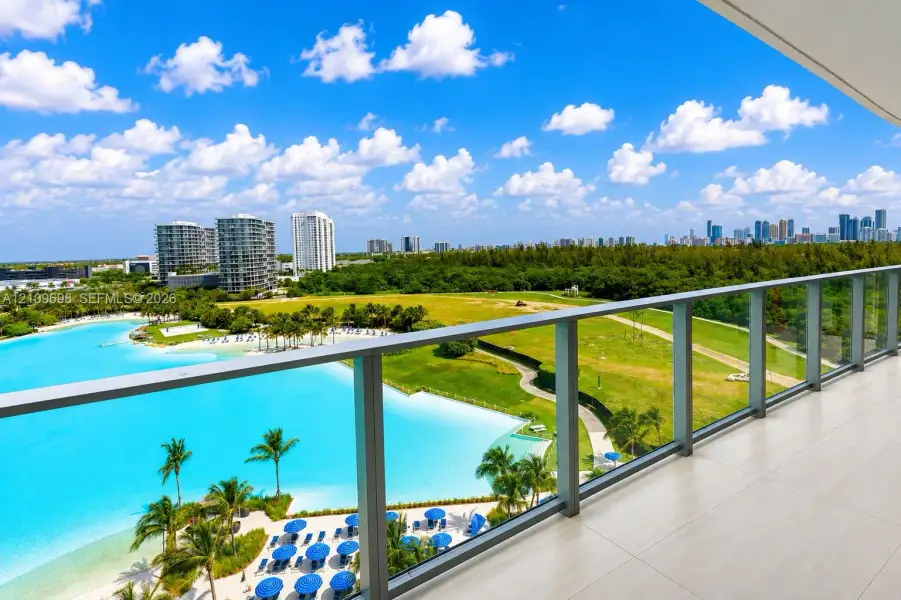 Covered balcony featuring large-format porcelain tile flooring and a glass-paneled railing with metal framing