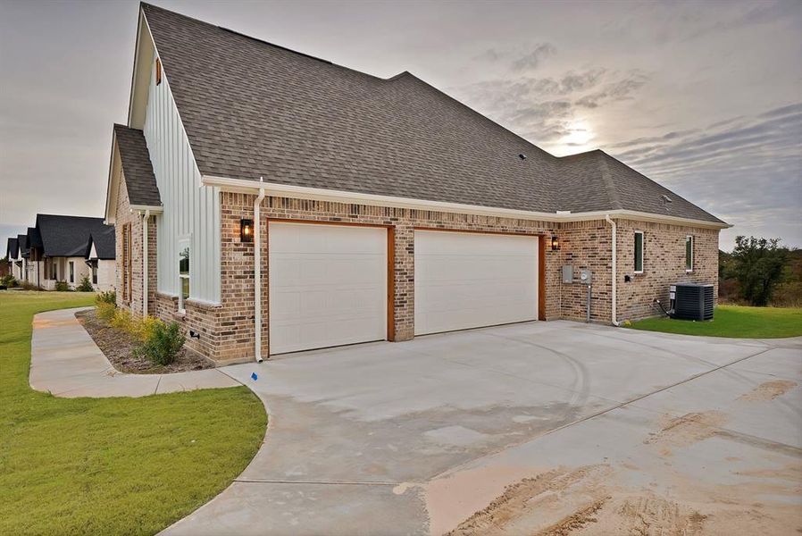 View of front of property featuring a front yard, brick siding, concrete driveway, and a garage View of front of property featuring a front yard, brick siding, concrete driveway, and a garage