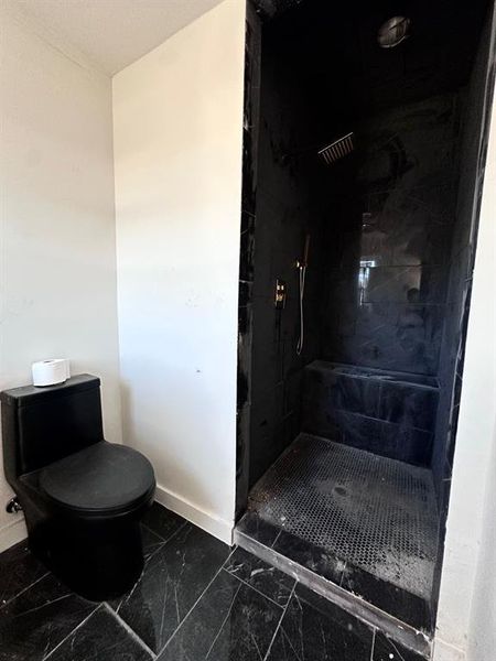 Bathroom with toilet and a tile shower