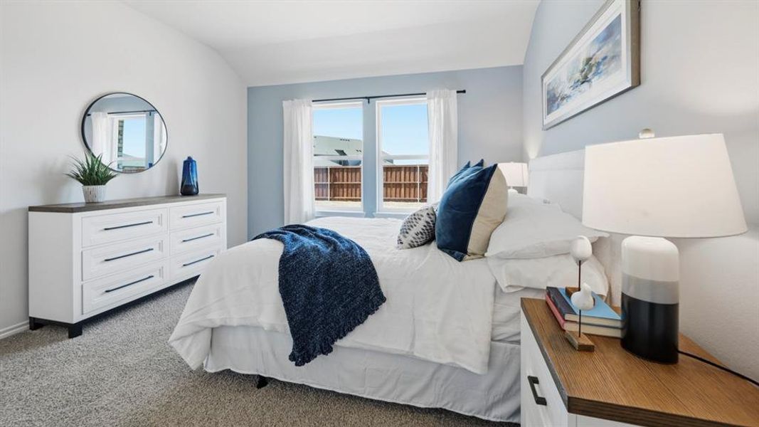 This room features a window with white curtains, carpeted floors, and light-colored walls