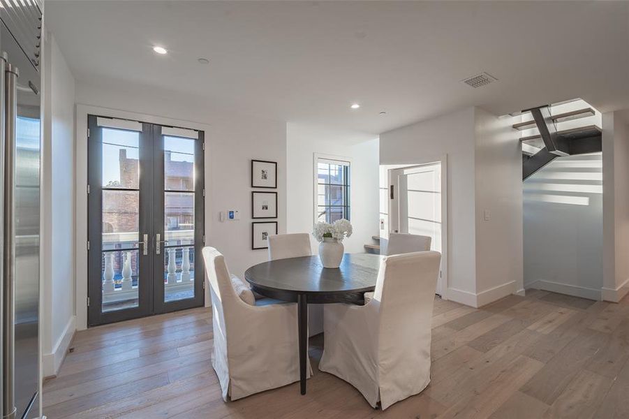 Dining area featuring french doors, a healthy amount of sunlight, and light wood flooring