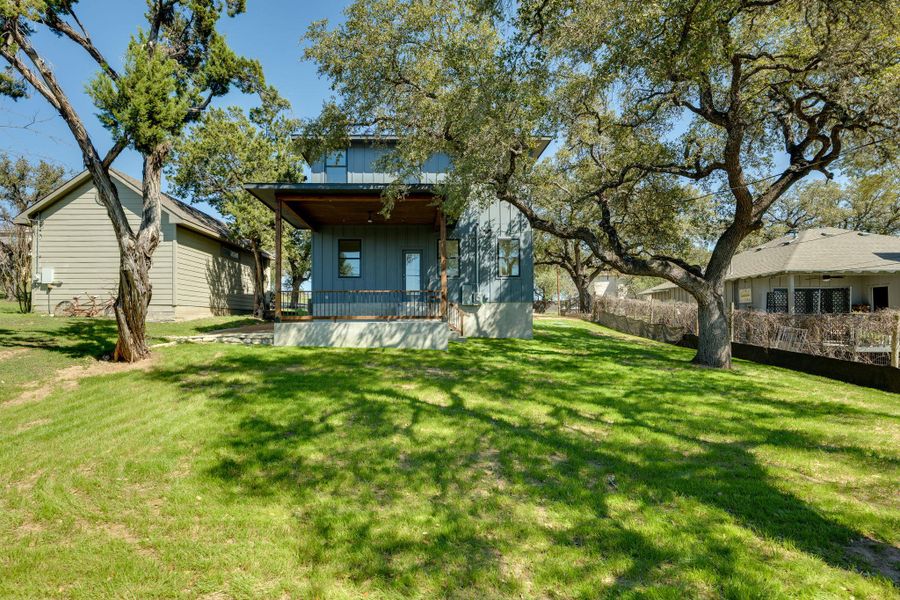 Flat backyard and three heritage oak trees.