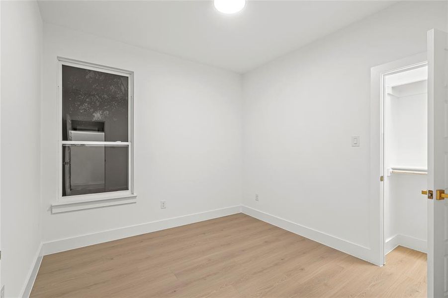 Spare room featuring light wood finished floors and baseboards