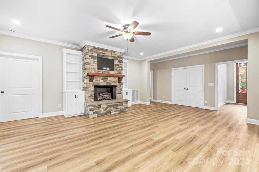 A warm gas log fireplace and built in cabinetry accentuate this large family room