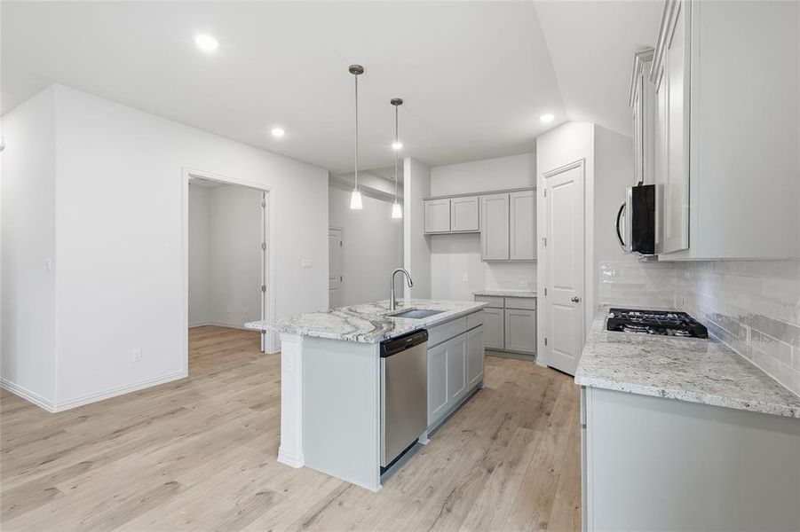 Modern kitchen featuring a central island with a double sink and pendant lighting Modern kitchen featuring a central island with a double sink and pendant lighting