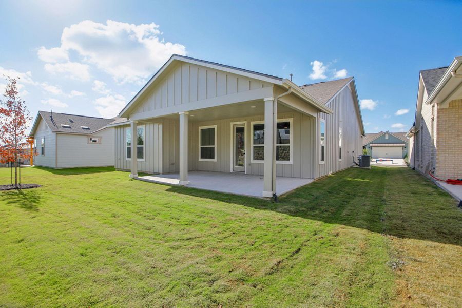 Back of property with board and batten siding, a patio area, and a yard Back of property with board and batten siding, a patio area, and a yard