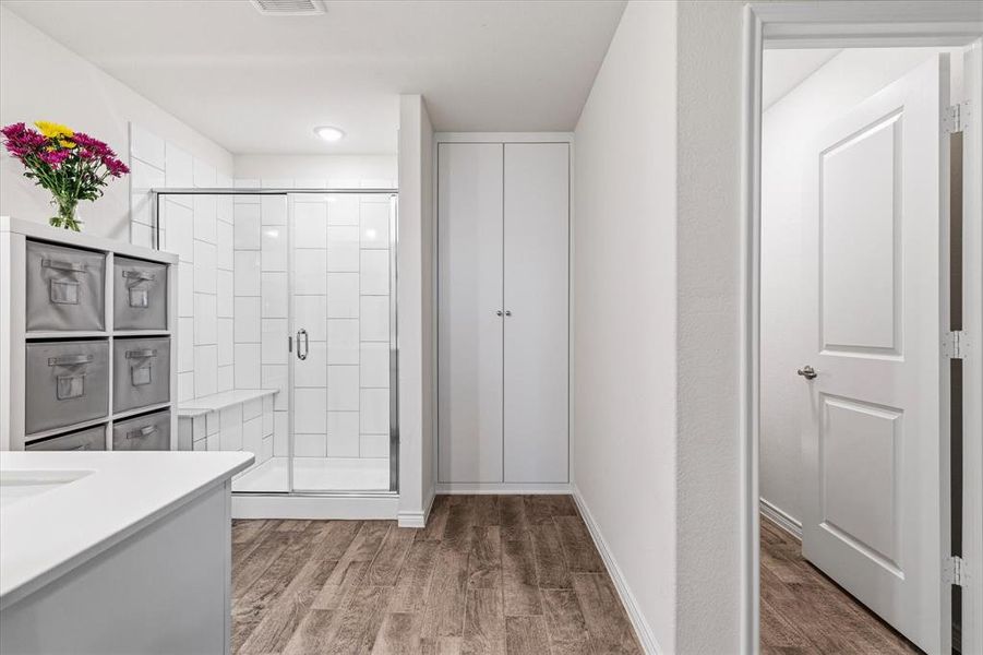 Primary bathroom featuring custom shelving for added storage and organization.