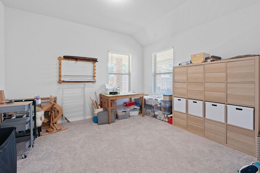 Carpeted office space featuring lofted ceiling and baseboards Carpeted office space featuring lofted ceiling and baseboards