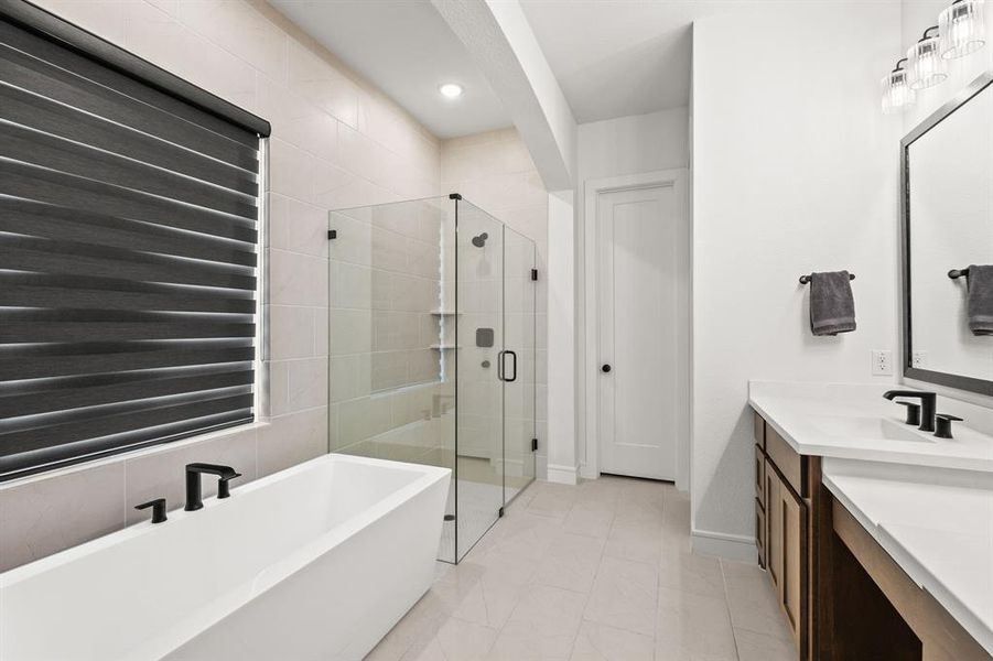 Master bathroom featuring long vanity with knee space, a soaking tub, a shower stall, light tile patterned flooring, and recessed lighting