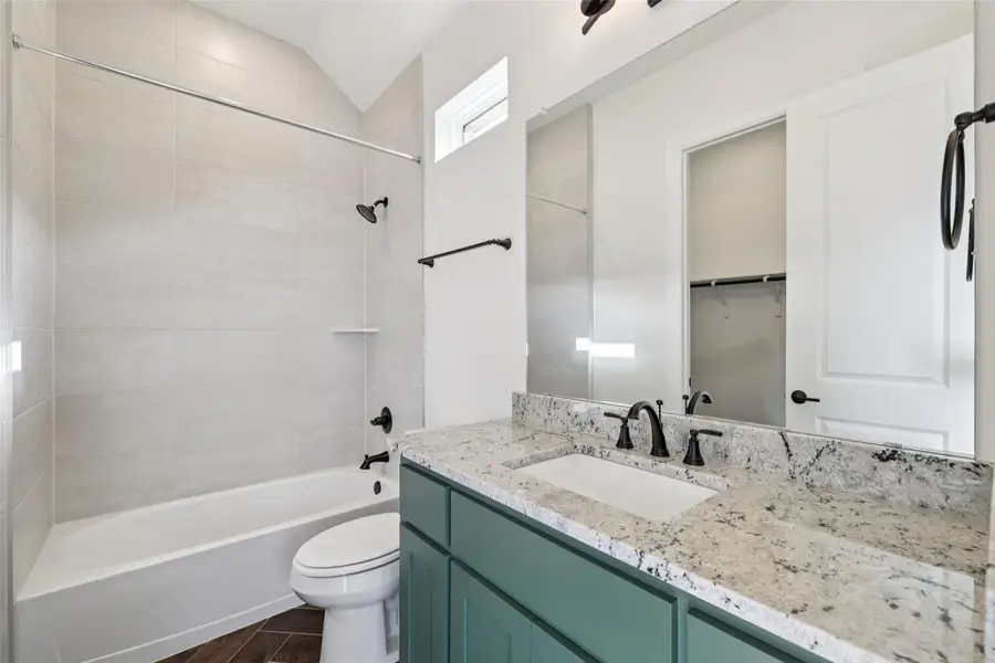 Full bathroom with vanity, shower / tub combination, and vaulted ceiling