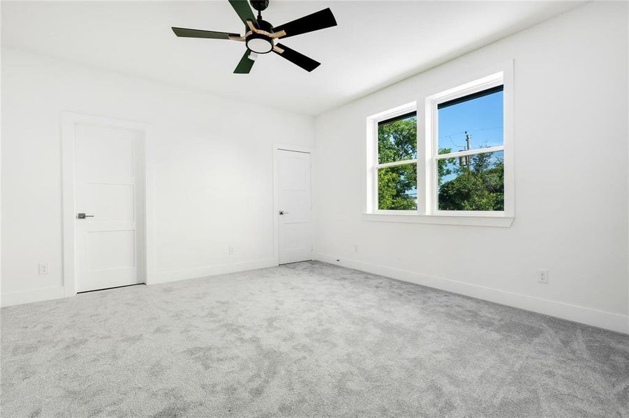 Carpeted empty room with ceiling fan