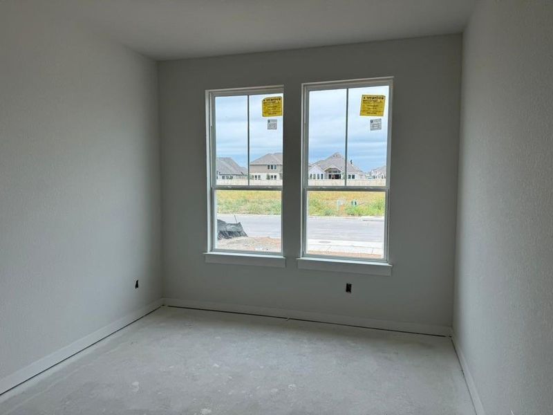 Spare room with baseboards and unfinished concrete flooring